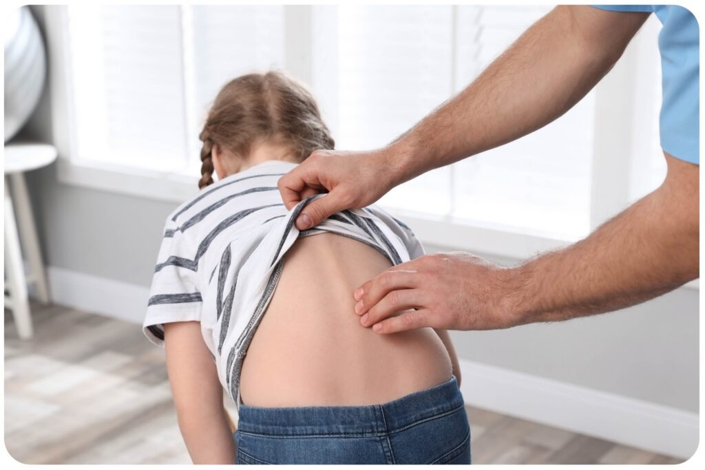 Czy dziecko wyrośnie z wady postawy? Kiedy zgłosić się do specjalisty? Badanie postawy ciała dziecka u fizjoterapeuty podczas oceny asymetrii kręgosłupa